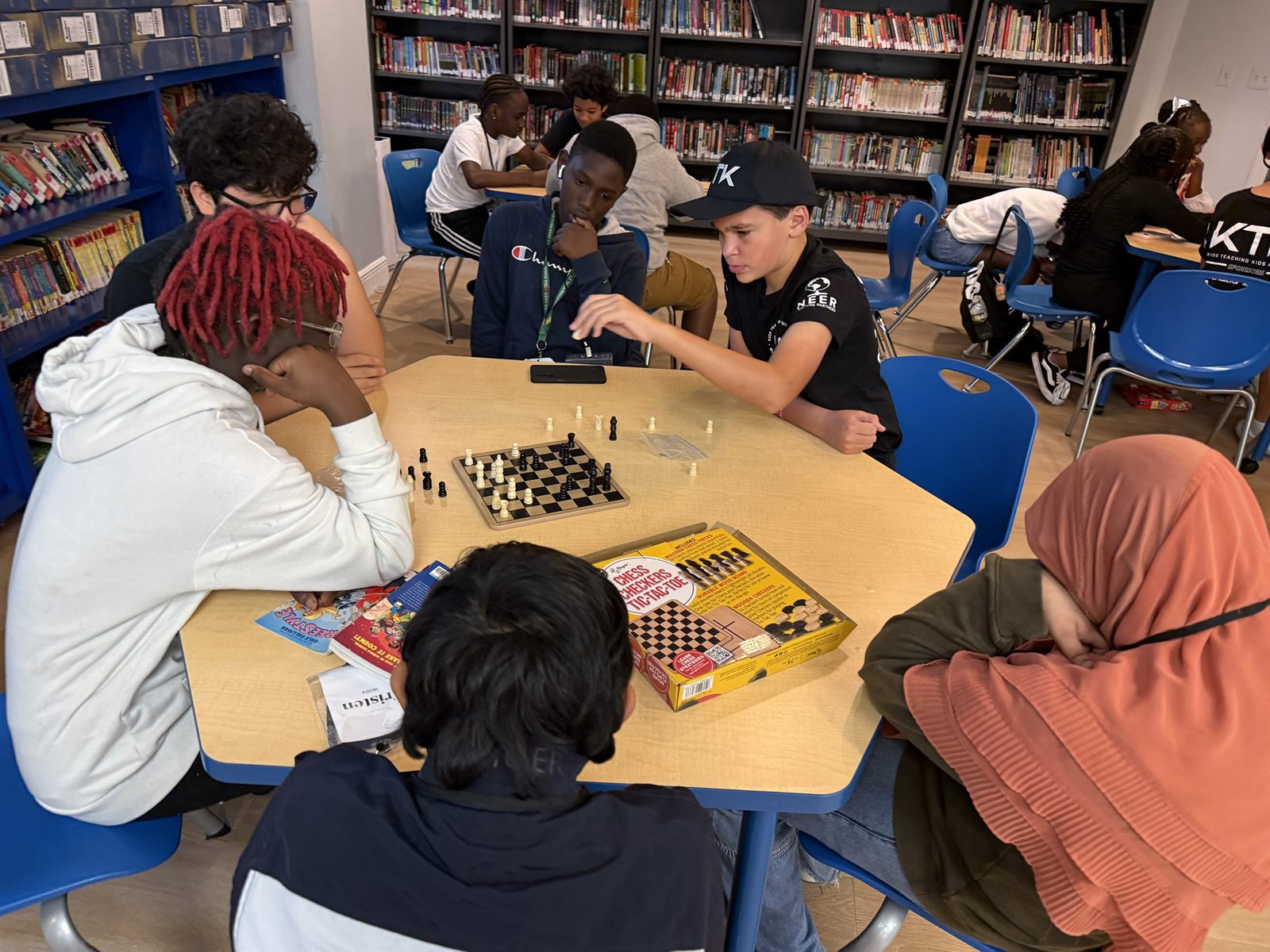 Campers playing chess at a camp table during a break