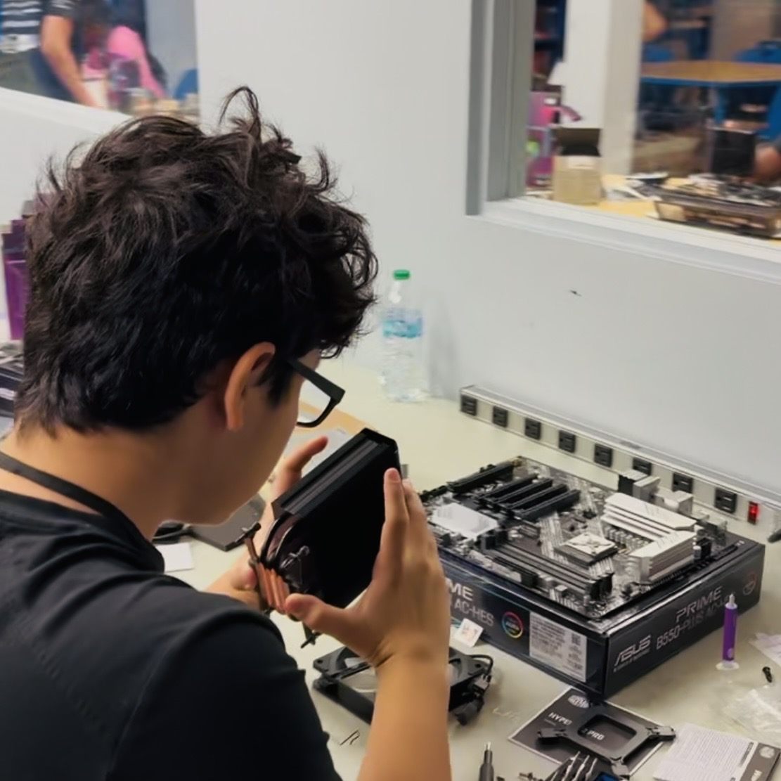 A camper holding the CPU cooler over the motherboard