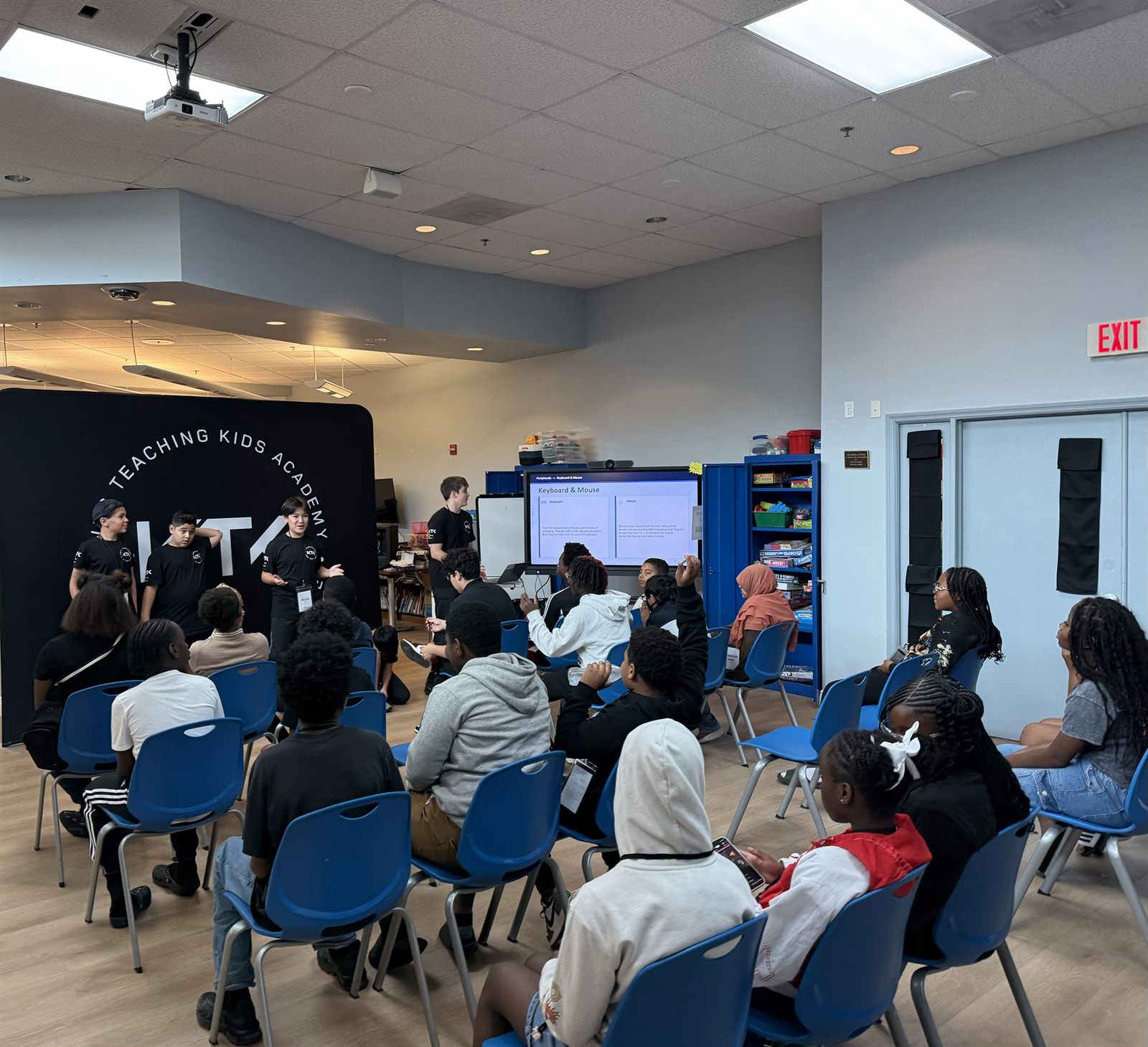 Three teachers presenting the keyboard and mouse slide to seated campers