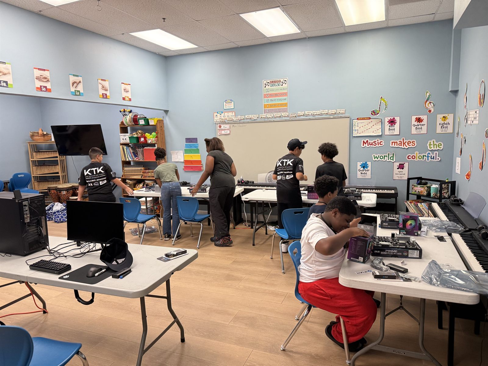 Campers building in a music classroom, keyboards pushed to the walls