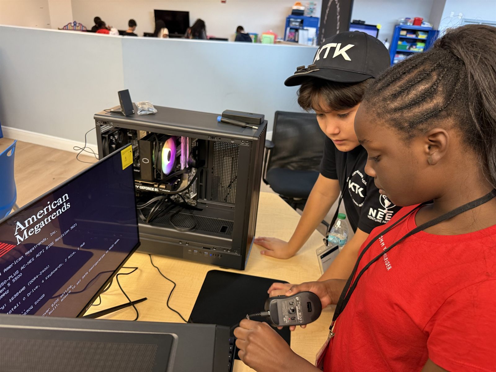 A camper plugging the mouse into the finished computer